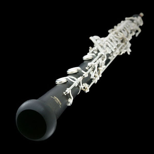 Black Yamaha oboe with silver keys against a dark background, a classical woodwind instrument and aerophone.