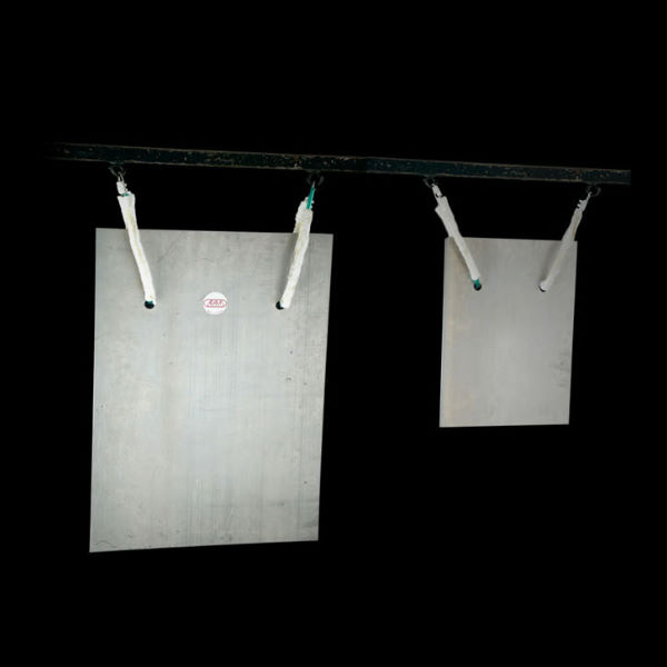 Pair of bell plates or Plattenglocken, rectangular metal instruments hanging from a black bar, against a dark background.