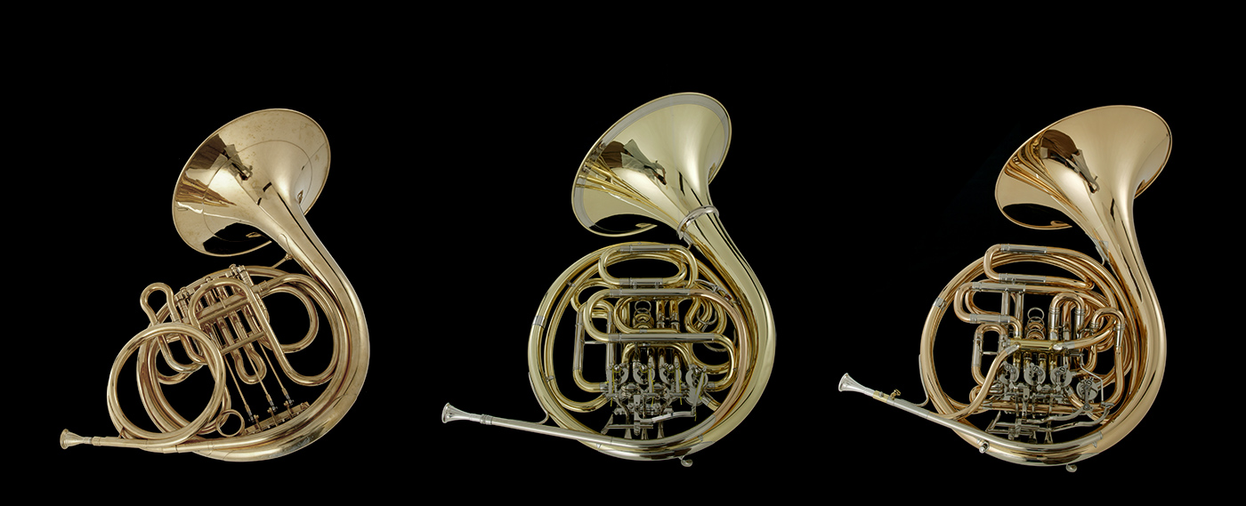 Three golden Viennese horns, or Wiener Horns in F, displayed against a black background