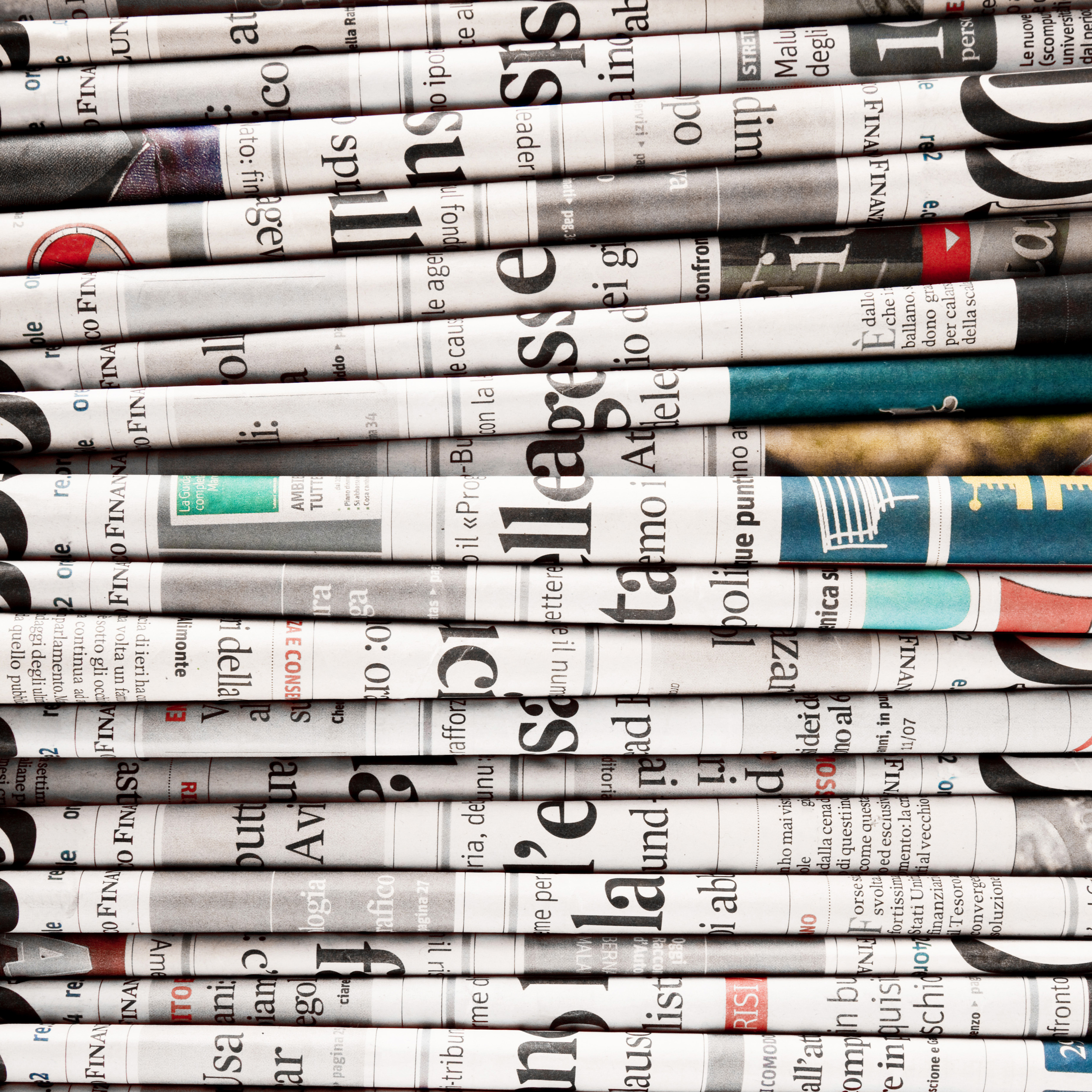 Stack of newspapers with headlines and articles visible, representing news, press releases, media, and current events.