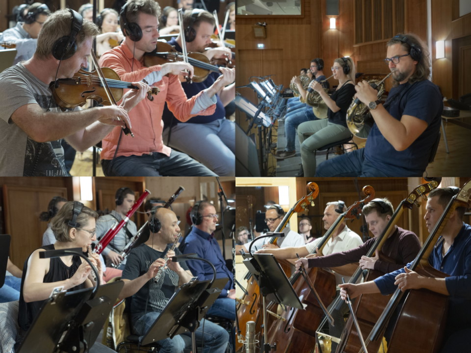 Orchestra musicians with headphones playing violins, French horns, flutes, and upright basses in a recording studio, highlighting the Big Bang Orchestra Synchron Instruments.