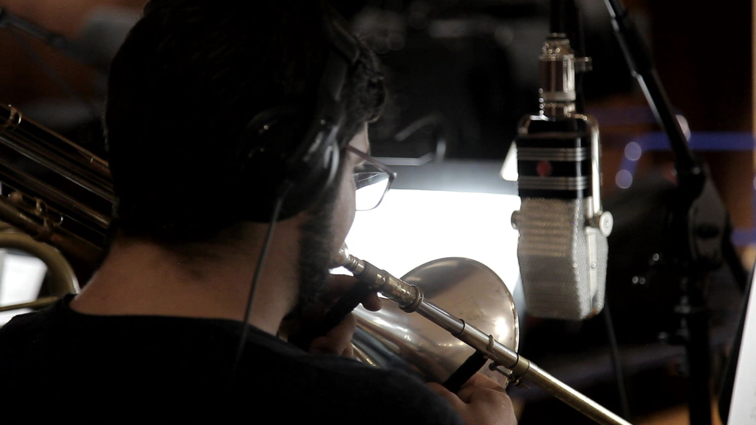 Synchron Percussion II: A variety of orchestral percussion instruments, including gongs, cymbals, and small bells, arranged on stands in a recording studio or concert hall.