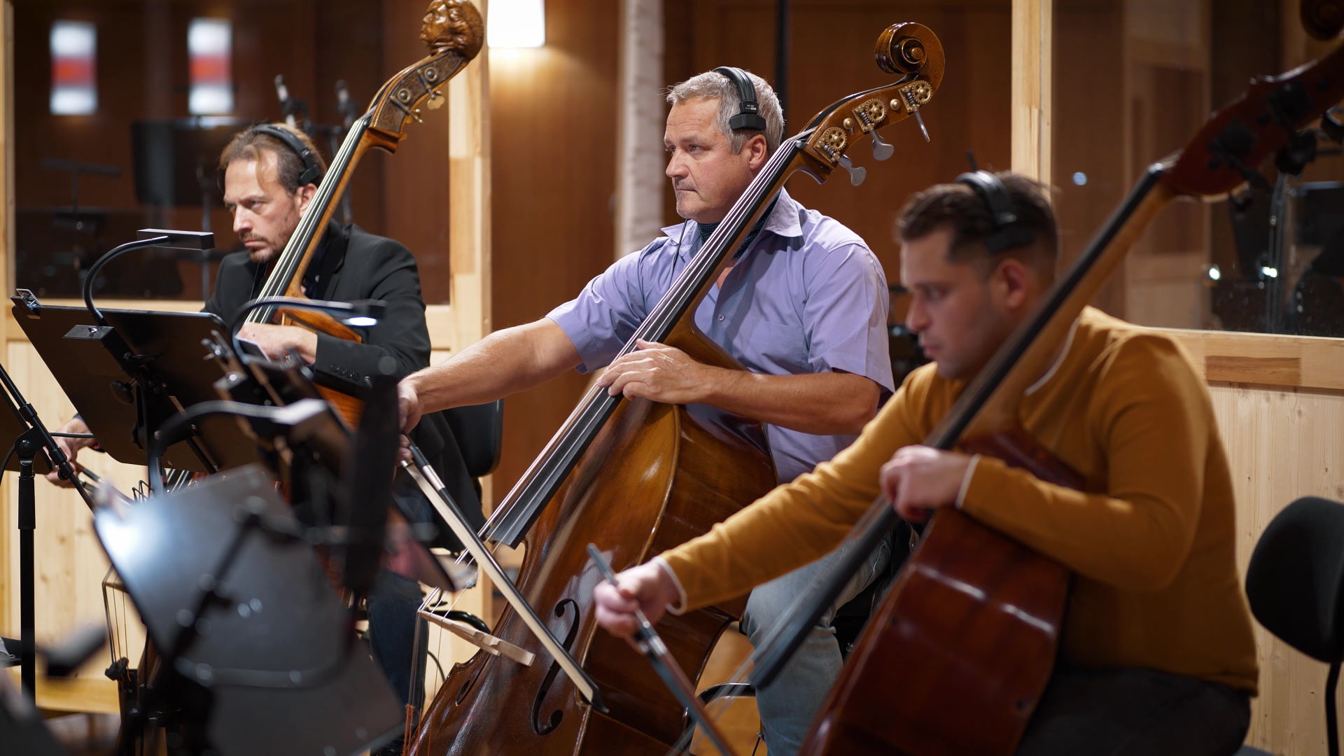 Multiple large metal sheet percussion instruments, possibly thunder sheets or gongs, arranged on stands in a recording studio or concert hall.