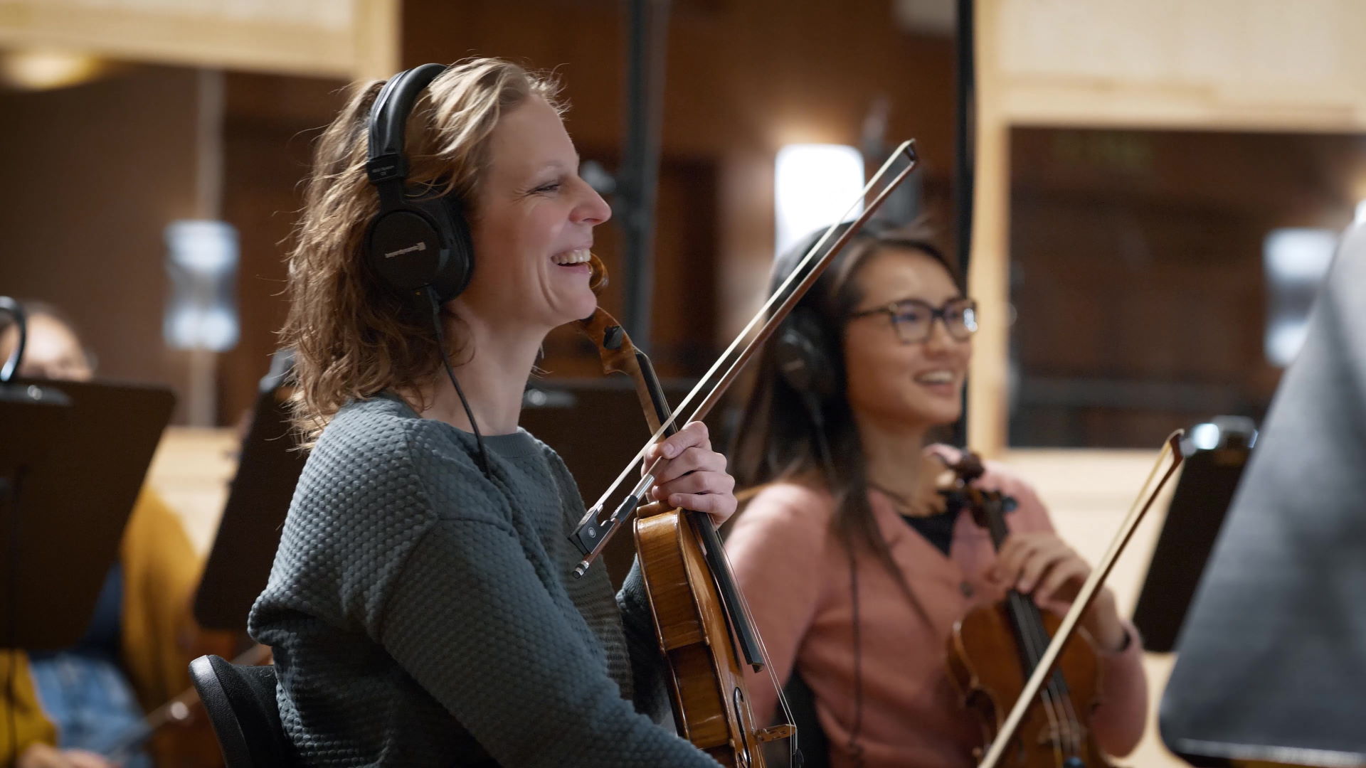 Synchron Percussion II: A variety of orchestral percussion instruments, including gongs, cymbals, and small bells, arranged on stands in a recording studio or concert hall.