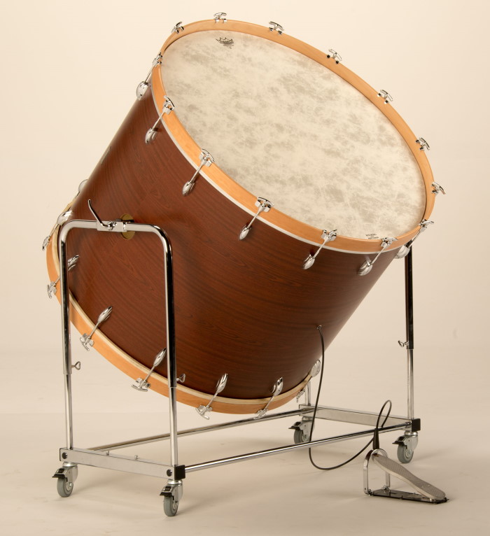 Adams concert bass drum on a stand, showcasing the drumhead, body, and mounting hardware against a black background.