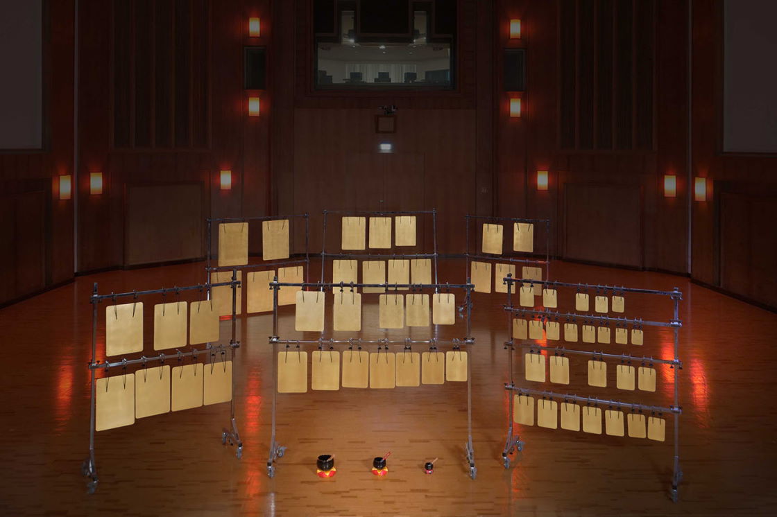 Multiple large metal sheet percussion instruments, possibly thunder sheets or gongs, arranged on stands in a recording studio or concert hall.
