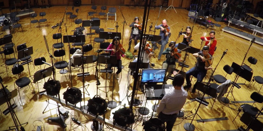 Orchestra members playing violins and other string instruments with microphones and recording equipment in a large studio, ideal for Vienna Symphonic Library Synchron Strings.