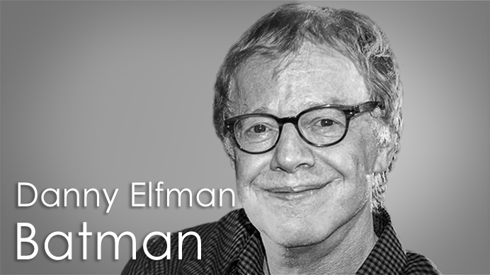 Black and white portrait of Danny Elfman, the composer for Tim Burton's 1992 Batman movie, smiling and wearing glasses.
