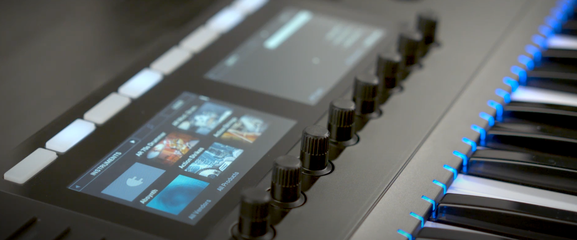 Close-up of a Native Instruments Komplete Kontrol keyboard with its screen displaying sound library options, control knobs, and illuminated keys, demonstrating NKS integration.