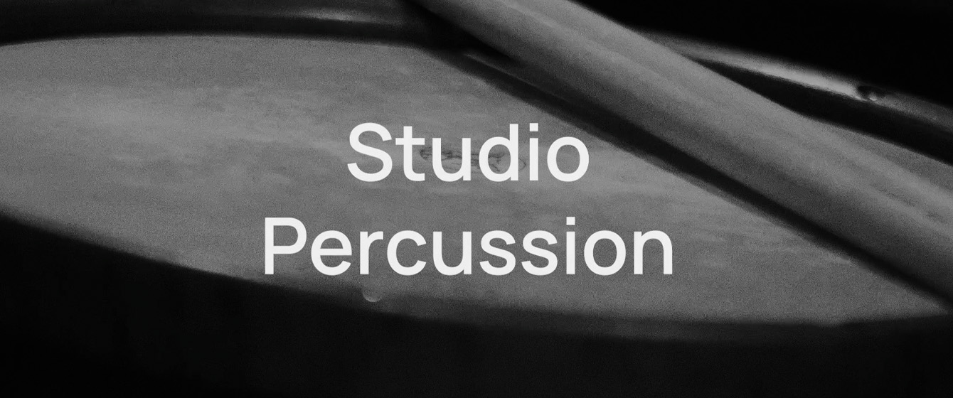 Black and white image with Studio Percussion text, showing a drum surface and drumsticks.