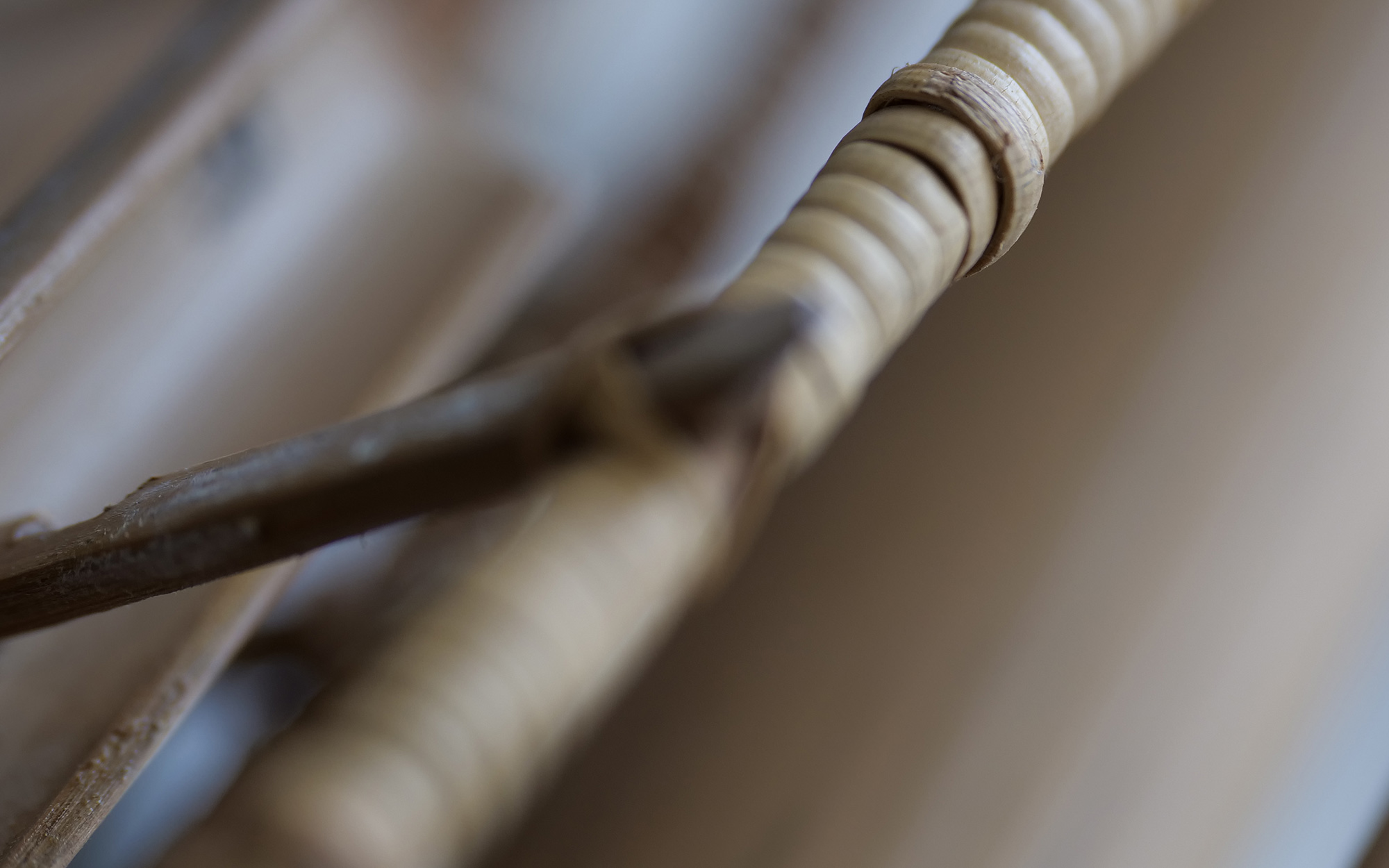 Close-up view of woven natural fiber or rattan furniture, showcasing textured details and craftsmanship.