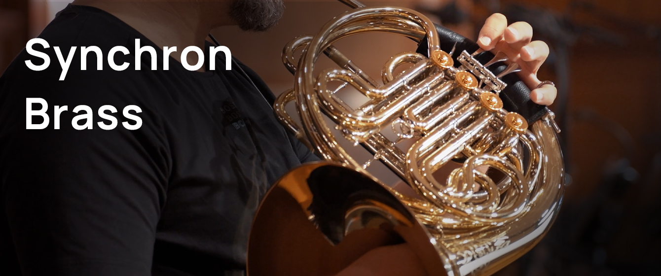 Person playing a shiny brass French horn, with text overlay Synchron Brass.