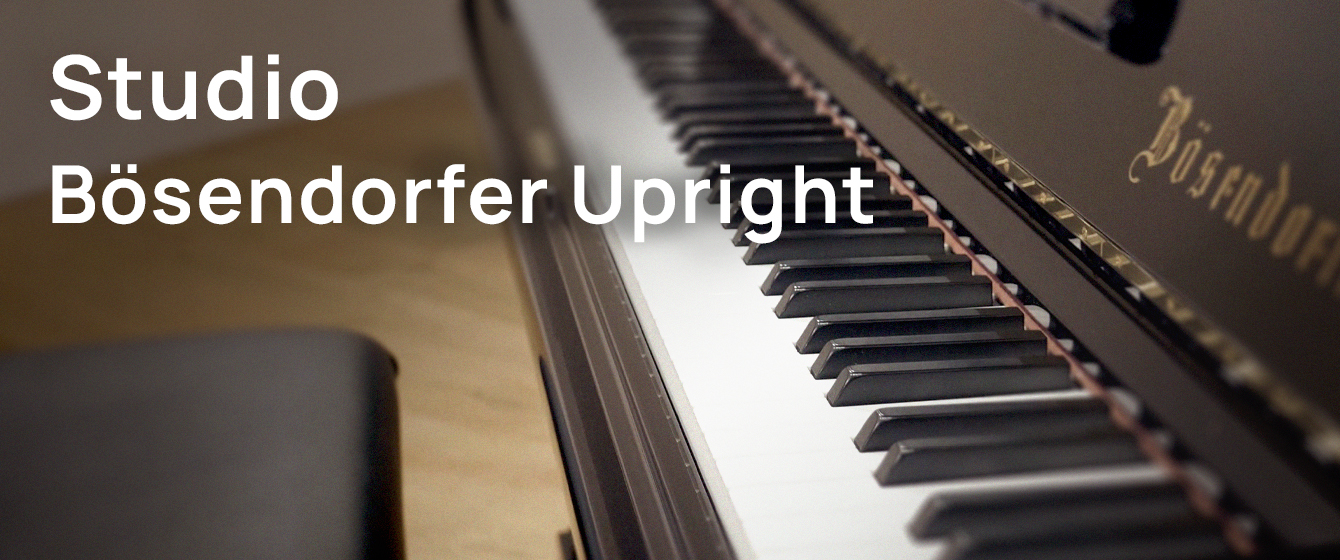Close-up of a dark brown Bösendorfer upright piano keyboard with white and black keys, displaying the Studio Bösendorfer Upright text.
