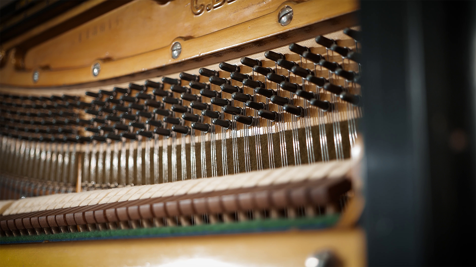 Close-up view of the intricate internal mechanisms of a piano, showing the hammers, strings, and dampers.