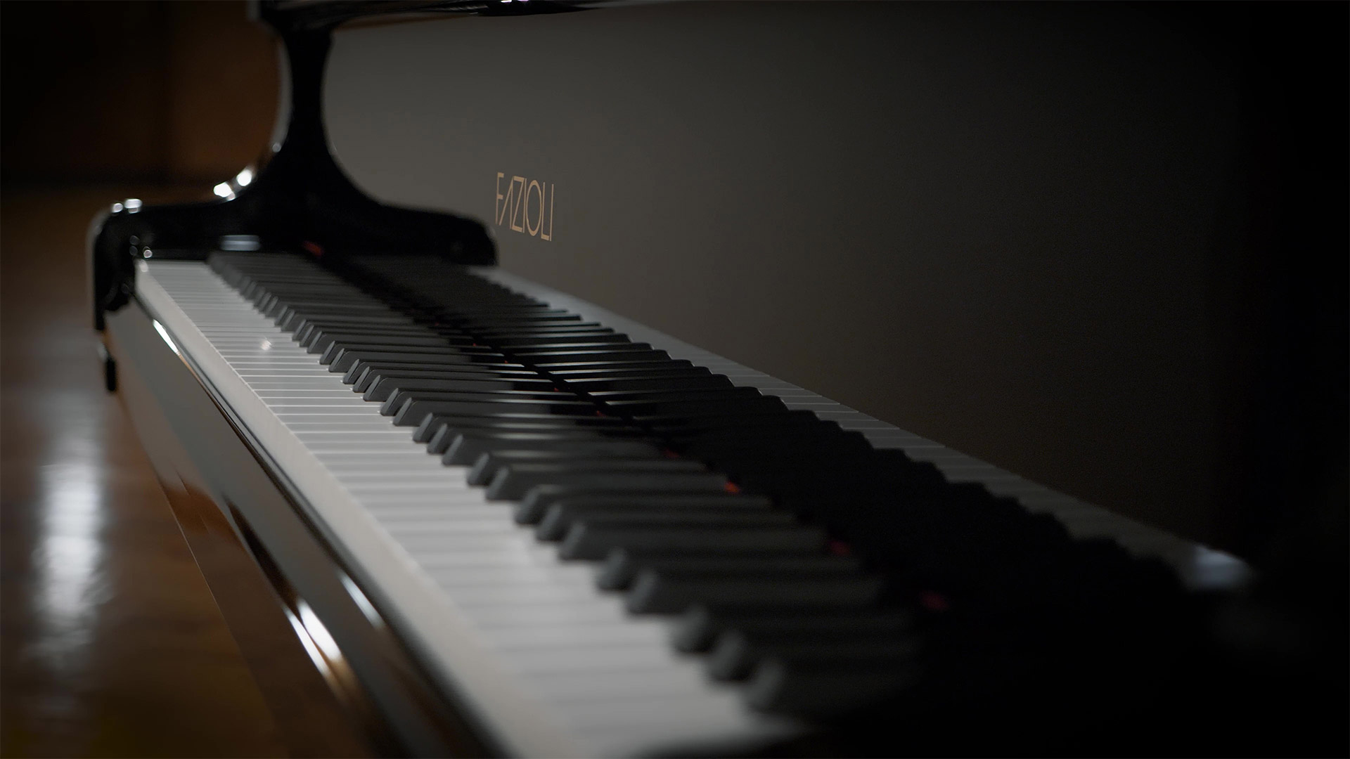 Close-up view of the Fazioli F308 concert grand piano keys, showcasing its elegant black and white keyboard with the gold Fazioli logo subtly visible on the side.
