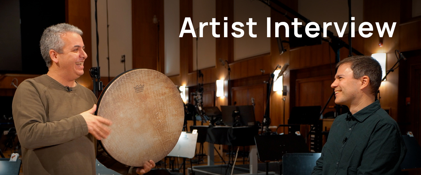 Hamidreza Ojaghi holding a daf percussion instrument during an artist interview with Andreas Olszewski.